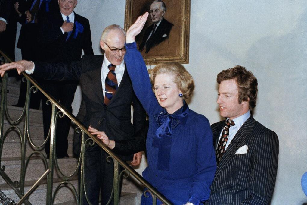 Mrs. Margaret Thatcher shown with her son, Mark, as she gives a jubilation wave at her party HQ on May 4, 1979 in London. (AP Photo/Dear)