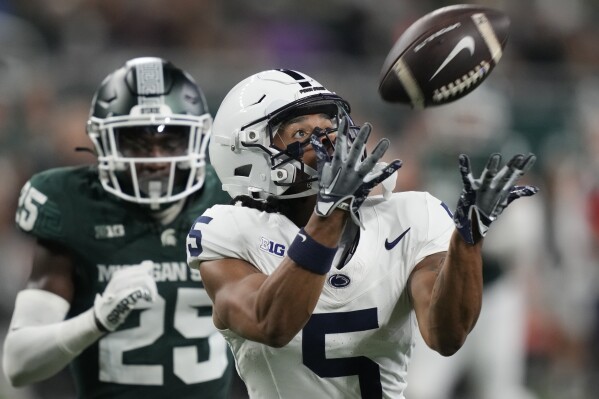 Penn State wide receiver Omari Evans (5), defended by Michigan State defensive back Chance Rucker (25), catches a pass to set up a touchdown during the second half of an NCAA college football game, Friday, Nov. 24, 2023, in Detroit. (AP Photo/Carlos Osorio)