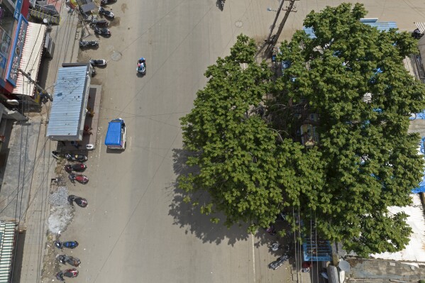 Preethi, a 38-year-old transgender woman who uses only her first name, rides her blue roofed electric auto rickshaw through a market in Bengaluru, India, Wednesday, July 12, 2023. Preethi said she wants to see more people take up electric vehicles, particularly other transgender women. (AP Photo/Aijaz Rahi)