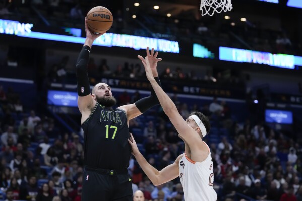 New Orleans Pelicans center Jonas Valanciunas (17) shoots against San Antonio Spurs forward Zach Collins in the first half of an NBA basketball game in New Orleans, Friday, Dec. 1, 2023. (AP Photo/Gerald Herbert)