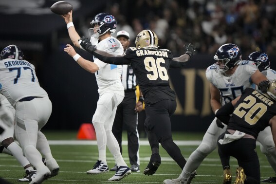 Tennessee Titans quarterback Ryan Tannehill, left, is pressured by New Orleans Saints defensive end Carl Granderson (96) in the first half of an NFL football game in New Orleans, Sunday, Sept. 10, 2023. (AP Photo/Gerald Herbert)