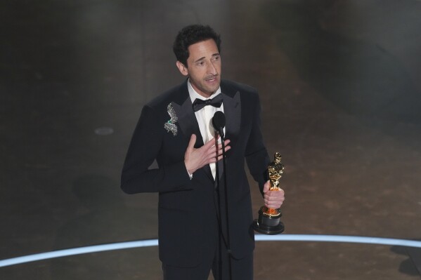 Adrien Brody accepts the award for best performance by an actor in a leading role for "The Brutalist" during the Oscars on Sunday, March 2, 2025, at the Dolby Theatre in Los Angeles.(AP Photo/Chris Pizzello)