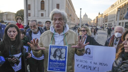 FILE - Pietro Orlandi wears a placard with a picture of his sister Emanuela during a sit-in near Saint Peter's Basilica, in Rome, Saturday, Jan. 14, 2023. The Vatican marked the 40th anniversary of the disappearance of the teenage daughter of a Vatican employee by confirming the existence of new leads “worthy of further investigation” in hopes of finally getting to the bottom of one of the Holy See’s enduring mysteries. (AP Photo/Gregorio Borgia, File)