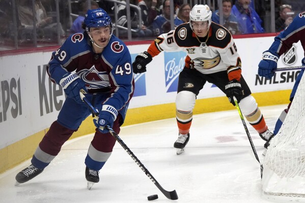 Colorado Avalanche defenseman Samuel Girard, left, collects the puck as Anaheim Ducks center Ryan Strome pursues in the second period of an NHL hockey game Wednesday, Nov. 15, 2023, in Denver. (AP Photo/David Zalubowski)