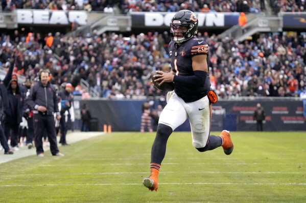 Chicago Bears quarterback Justin Fields heads to the end zone for a touchdown as head coach Matt Eberflus watches along the sidelines during the second half of an NFL football game against the Detroit Lions Sunday, Dec. 10, 2023, in Chicago. (AP Photo/Nam Y. Huh)