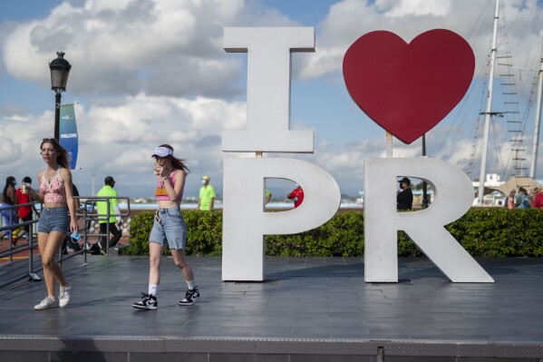 FILE - Tourists walk through the docking area after exiting Carnival's Mardi Gras cruise ship in the bay of San Juan, Puerto Rico, Aug. 3, 2021, marking the first time a cruise ship visits the U.S. territory since the COVID-19 pandemic began. On Aug. 8, 2023, San Juan Mayor Miguel Romero signed a measure to prohibit alcohol sales after certain hours, which goes into effect in November 2023. (AP Photo/Carlos Giusti, File)