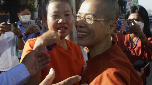 FILE - Theary Seng, right, a Cambodian-American lawyer, dressed in a prison-style orange outfit, greets her supporters as she arrived at Phnom Penh Municipal Court in Phnom Penh, Cambodia, on Jan. 4, 2022. The United Nations Working Group on Arbitrary Detention said in a judgement late Wednesday, July 12, 2023, that while attorney Theary Seng had been convicted of conspiracy to commit treason and other charges last year, her only crime was “making two posts on Facebook critical of Hun Sen,” Cambodia's autocratic prime minister. (AP Photo/Heng Sinith, File)