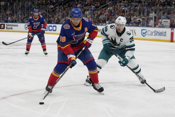 St. Louis Blues' Robert Thomas (18) handles the puck as San Jose Sharks' Logan Couture (39) defends during the second period of an NHL hockey game Thursday, March 9, 2023, in St. Louis. (AP Photo/Jeff Roberson)