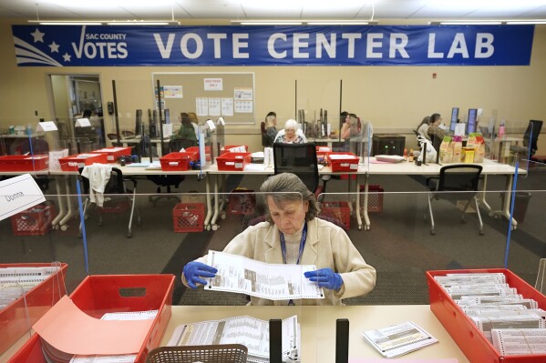 FILE - Election worker Donna Young inspects a mail-in ballot for damage at the Sacramento County Registrar of Voters in Sacramento, Calif., June 3, 2022. (AP Photo/Rich Pedroncelli, File)