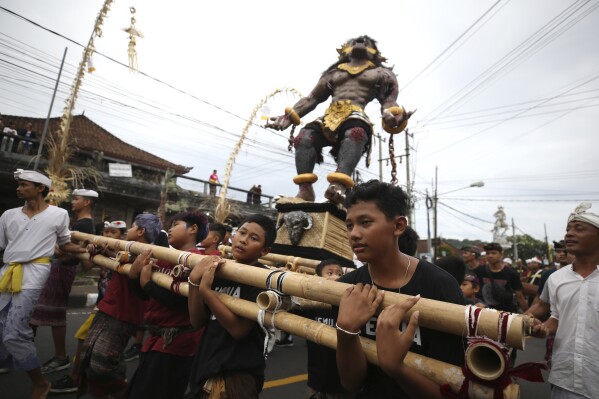 Boys carry an effigy during Ogoh-ogoh parade, as part of the Balinese Hindu New Year celebrations, in Bali, Indonesia on Sunday, March 10, 2024. The noisy "ogoh-ogoh" processions feature giant scary figures that symbolize evil spirits and are burned in a ritualistic purification, signifying the victory of good over evil.(AP Photo/Firdia Lisnawati)