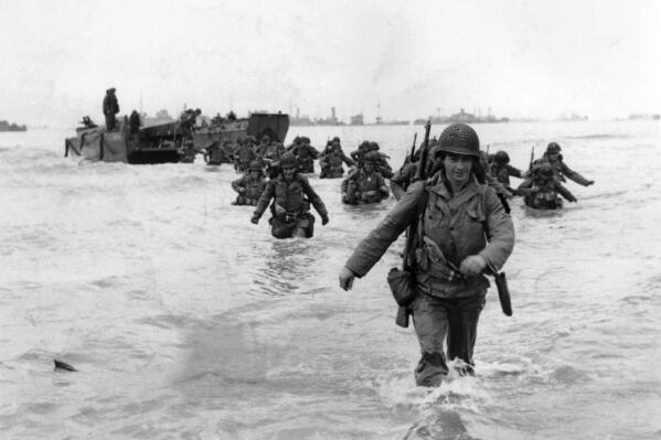 FILE - U.S. infantrymen wade through the surf as they land at Normandy in the days following the Allies' June 1944, D-Day invasion of occupied France. (AP Photo/Bert Brandt, File)