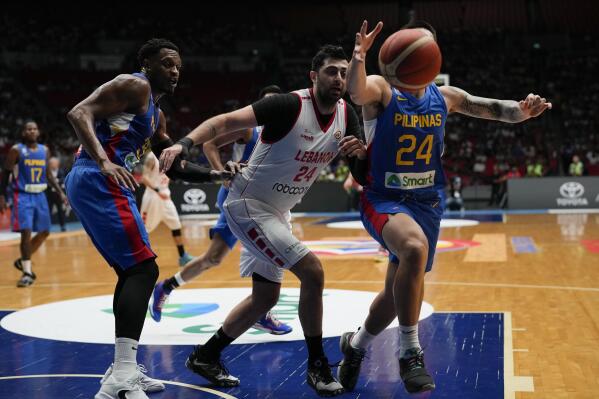 Philippines' Dwight Ramos, right, against Lebanon's Hayk Gyokchyan, center, during their FIBA Basketball World Cup 2023 Asian Qualifiers game at the Philippine Arena in Bulacan province, north of Manila, Philippines on Friday Feb. 24, 2023. (AP Photo/Aaron Favila)