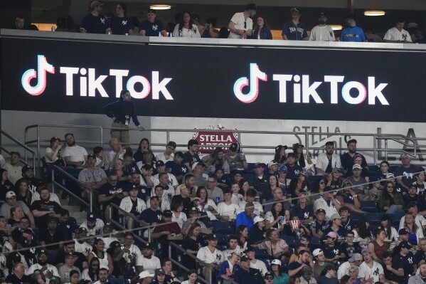 FILE - Fans sit under a TikTok ad at a baseball game at Yankee Stadium, April 14, 2023, in New York. President Joe Biden's campaign is embracing TikTok to court younger voters ahead of the U.S. presidential elections, but U.S. adults seem to be split about whether the video-sharing app should even operate in the country. (APPhoto/Frank Franklin II, File)