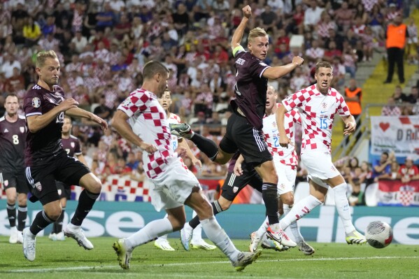 Croatia's Andrej Kramaric, second left, scores his side's fourth goal during the Euro 2024 group D qualifying soccer match between Croatia and Latvia at Rujevica stadium in Rijeka, Croatia, Friday, Sept. 8, 2023. (AP Photo/Darko Bandic)