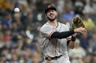 FILE -San Francisco Giants' Kris Bryant throws out Milwaukee Brewers' Avisail Garcia at first base during the first inning of a baseball game Saturday, Aug. 7, 2021, in Milwaukee. Veteran slugger Kris Bryant has agreed to a $182 million, seven-year deal to join the Colorado Rockies, according to a person familiar with the agreement. The person confirmed the deal to The Associated Press on condition of anonymity Wednesday, March 16, 2022 because its completion is pending a successful physical. (AP Photo/Aaron Gash, File)