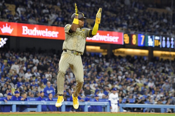 San Diego Padres' José Azocar celebrates as he scores on a single by Jackson Merrill during the 11th inning of a baseball game against the Los Angeles Dodgers Friday, April 12, 2024, in Los Angeles. (AP Photo/Mark J. Terrill)
