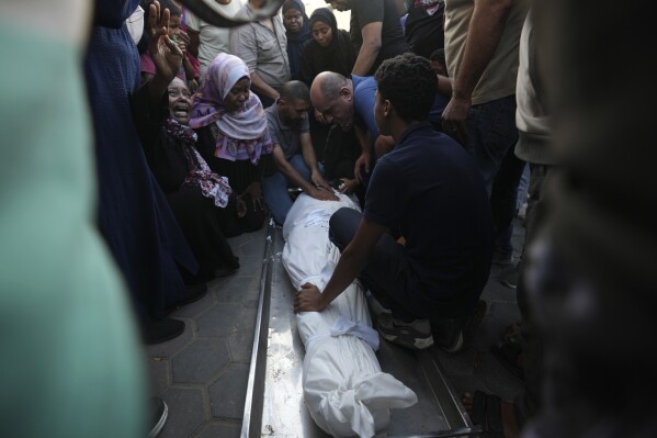 Palestinians mourn a relative killed in the Israeli bombardment of the Gaza Strip outside a hospital in Deir Al-Balah on Wednesday, Oct. 25, 2023. (AP Photo/Adel Hana)