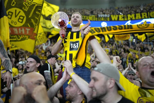 Borussia Dortmund supporters celebrate at the end of the Champions League semifinal second leg soccer match between Paris Saint-Germain and Borussia Dortmund at the Parc des Princes stadium in Paris, France, Tuesday, May 7, 2024. (AP Photo/Lewis Joly)