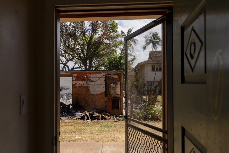 The burnt house next to Daniel Skousen's home is seen from Skusen's front door on Friday, Nov. 3, 2023, in Lahaina, Hawaii. (AP Photo/Mengshin Lin)
