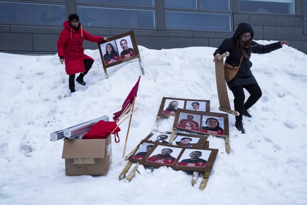 Women carry political placards for the upcoming elections in Nuuk, Greenland, March 8, 2025. (AP Photo/Evgeniy Maloletka)