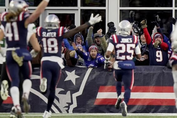 New England Patriots fans celebrate as cornerback Marcus Jones (25) scores on a punt return during the final minute of the second half of an NFL football game against the New York Jets, Sunday, Nov. 20, 2022, in Foxborough, Mass. The Patriots won 10-3. (AP Photo/Steven Senne)