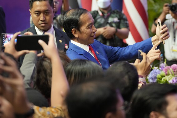 Indonesian President Joko Widodo takes a selfie with the media during a press conference at the end of the Association of Southeast Asian Nations (ASEAN) Summit in Jakarta, Indonesia, Thursday, Sept. 7, 2023. (AP Photo/Achmad Ibrahim)