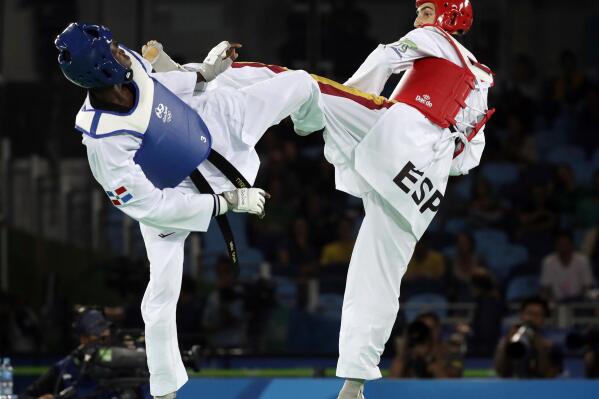 FILE - In this Aug. 17, 2016, file photo, Luisito Pie, of the Dominican Republic, left, and Jesus Tortosa, of Spain, compete in a men's Taekwondo bronze medal final at the 2016 Summer Olympics in Rio de Janeiro, Brazil, Wednesday, Aug. 17, 2016. One of the world's top-ranked taekwondo fighters is taking vacation in the Dominican Republic instead of competing at the Tokyo Olympics after being surprisingly excluded from the Games by the Spanish federation. Tortosa is among a few athletes worldwide who earned Olympic qualification but won’t be in Japan because in some sports the final decision on picking the teams is made by the local federations. (AP Photo/Andrew Medichini, File)