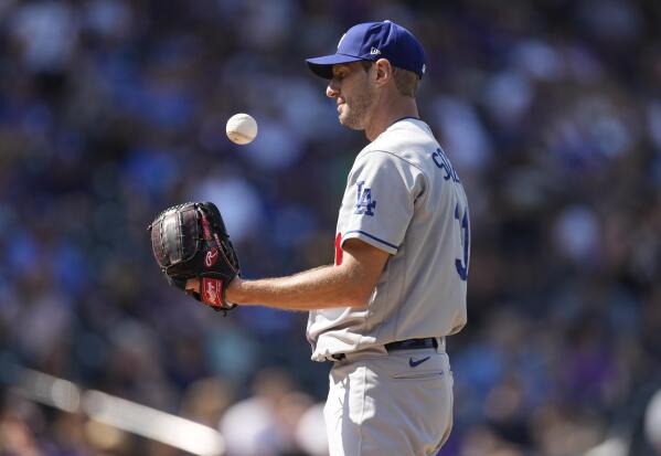 FILE - Los Angeles Dodgers starting pitcher Max Scherzer tosses the ball during the third inning of the team's baseball game against the Colorado Rockies on Sept. 23, 2021, in Denver. Sometime soon, lockout costs become real: Scherzer would forfeit $232,975 for each regular-season day lost and Gerrit Cole $193,548. Based on last year's base salaries that totaled just over $3.8 billion, major league players would combine to lose $20.5 million for each day wiped off the 186-day regular season schedule. (AP Photo/David Zalubowski, File)
