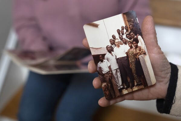 Anna Eisenberg, left, and her mother Cathy Votaw, 69, look at photographs of Votaw's father, Albert Votaw, during his service with USAID in West Africa, Thursday, Feb. 27, 2025, at their home in Washington. (AP Photo/Jacquelyn Martin)