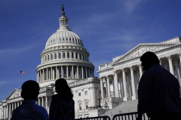FILE - People walk outside the U.S Capitol building in Washington, June 9, 2022. (AP Photo/Patrick Semansky, File)