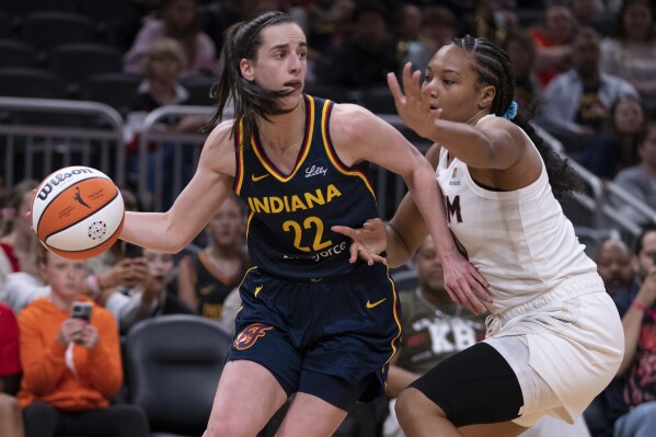 Indiana Fever's Caitlin Clark (22) looks to pass the ball as Atlanta Dream's Naz Hillmon defends during the second half of a WNBA preseason basketball game Thursday, May 9, 2024, in Indianapolis. (AP Photo/Darron Cummings)