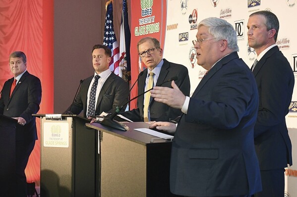 FILE - Attorney General Patrick Morrisey, in foreground, speaks as West Virginia gubernatorial candidates, from left, Mac Warner, Chris Miller, moderator and MetroNews Radio host Hoppy Kercheval and Moore Capito participate in a GOP debate held at The Resort at Glade Springs, Feb. 6, 2024, in Daniels, W.Va. When West Virginia Republicans vote in the primary on Tuesday, May 14, they will have a hard time finding a major candidate on the ballot in any statewide race who openly acknowledges that President Joe Biden won the 2020 election. (Rick Barbero/The Register-Herald via Ǻ, File)