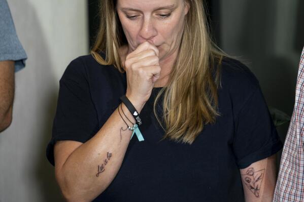 Nichole Schmidt, mother of Gabby Petito, whose death on a cross-country trip has sparked a manhunt for her boyfriend Brian Laundrie, holds back tears during a news conference, Tuesday, Sept. 28, 2021, in Bohemia, N.Y. Schmidt, along with Petito's father and two stepparents, were recently tattooed in memory of their child with the words, "Let it be." (AP Photo/John Minchillo)