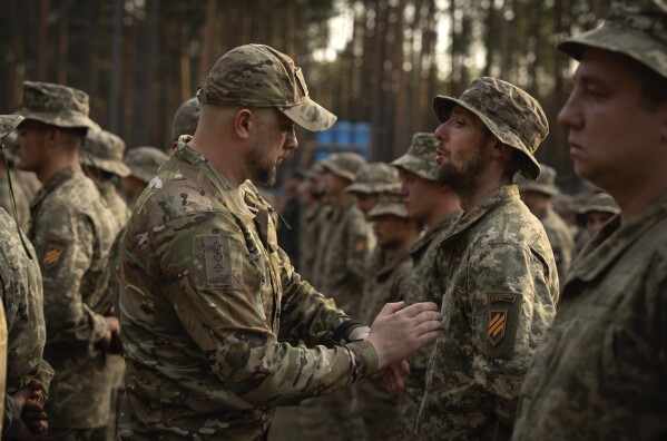 FILE - Newly recruited soldiers who mark the end of their training at a military base close to Kyiv, Ukraine, on Sept. 25, 2023. Two years after Russia’s full-scale invasion captured nearly a quarter of the country, the stakes could not be higher for Kyiv. After a string of victories in the first year of the war, fortunes have turned for the Ukrainian military, which is dug in, outgunned and outnumbered against a more powerful opponent. (AP Photo/Efrem Lukatsky, File)