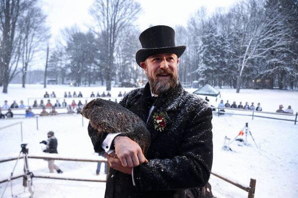 Groundhog Club handler A.J. Dereume holds Punxsutawney Phil, the weather prognosticating groundhog, during the 135th celebration of Groundhog Day on Gobbler's Knob in Punxsutawney, Pa., Tuesday, Feb. 2, 2021. Phil's handlers said that the groundhog has forecast six more weeks of winter weather during this year's event that was held without anyone in attendance due to potential COVID-19 risks. (AP Photo/Barry Reeger)