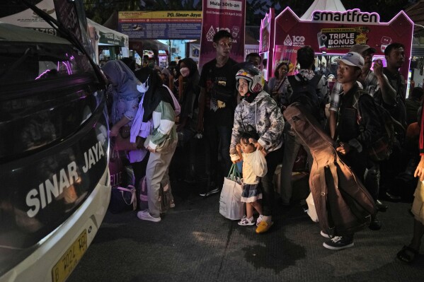 FILE - People wait for the buses that will take them to their hometowns at Kalideres bus terminal, in Jakarta, Indonesia, Tuesday, April 18, 2023, a week before the Eid-al Fitr holiday. (AP Photo/Dita Alangkara, File)