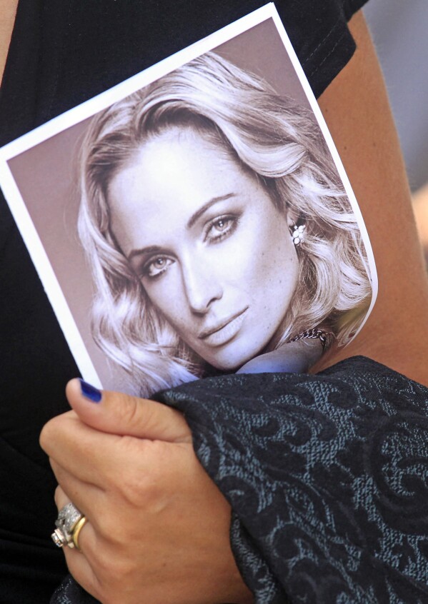 ARCHIVO - Un doliente lleva un programa en el funeral de Reeva Steenkamp, ​​en Port Elizabeth, Sudáfrica, el 19 de febrero de 2013. El viernes 5 de enero de 2024, Oscar Pistorius saldrá de prisión en libertad condicional para vivir bajo estrictas condiciones. Condiciones en una casa familiar después de cumplir casi nueve años de su condena por asesinato por matar a tiros a su novia Reeva Steenkamp el día de San Valentín de 2013. (Foto AP/Schalk van Zuydam, archivo)
