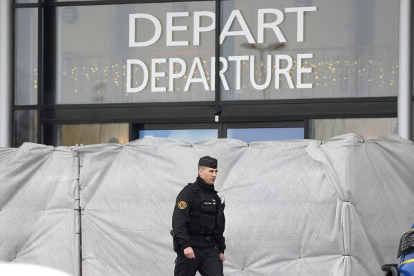A police officer patrols Vatry Airport, eastern France, Saturday, Dec. 23, 2023.  Nearly 300 Indian nationals bound for Central America remained detained at a French airport for the third day on Saturday amid an investigation into suspected human trafficking, officials said.  The 15 crew members of a Legend Airlines charter flight en route from the United Arab Emirates to Nicaragua were questioned and released, according to a lawyer for the small Romania-based airline.  (AP Photo/Christophe Anna)