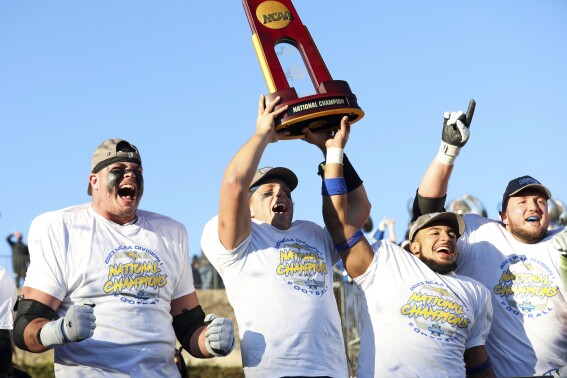 From left to right, South Dakota State's Garret Greenfield, quarterback Mark Gronowski, Jason Freeman and Mason McCormick celebrate with the trophy after their win over Montana at the FCS Championship NCAA college football game Sunday, Jan. 7, 2024, in Frisco, Texas. (AP Photo/Richard W. Rodriguez)