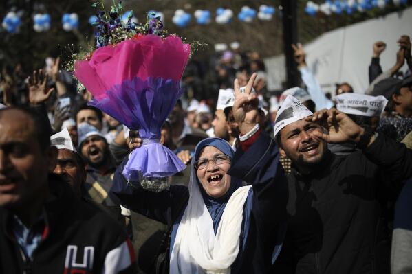 Supporters of the Aam Aadmi Party, or "common man's" party, celebrate the party's victory, at their party office in New Delhi, India, Tuesday, Feb. 11, 2020. The polls put Indian Prime Minister Narendra Modi's Bharatiya Janata Party against the incumbent Aam Aadmi Party, whose pro-poor policies have focused on fixing state-run schools and providing free health care and bus fares for women during the five years in power. (AP Photo/Altaf Qadri)
