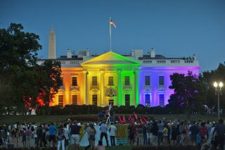 FILE - In this Friday, June 26, 2015 file photo, people gather in Lafayette Park to see the White House illuminated with rainbow colors in commemoration of the Supreme Court's ruling to legalize same-sex marriage in Washington. The Trump administration Friday, June 12, 2020, finalized a regulation that overturns Obama-era protections for transgender people against sex discrimination in health care. (AP Photo/Pablo Martinez Monsivais, File)