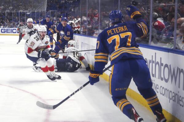Florida Panthers and Buffalo Sabres players watch as the puck flies past Sabres' JJ Peterka during an NHL hockey game Saturday, Oct. 15, 2022, in Buffalo, N.Y. (Joseph Cooke/The Buffalo News via AP)