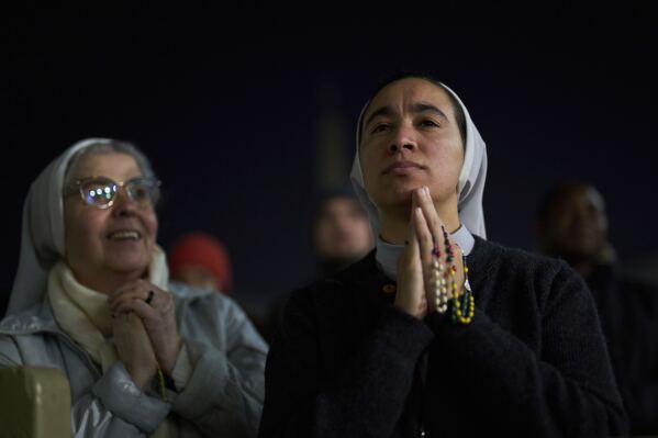 Catholic nuns listen to a recorded message from Pope Francis during a vigil rosary for his health in St. Peter's Square at The Vatican, Thursday, March 6, 2025. (AP Photo/Francisco Seco)