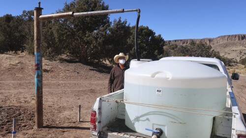 FILE - Phillip Yazzie waits for a water drum in the back of his pickup truck to be filled in Teesto, Ariz., on the Navajo Nation, on Feb. 11, 2021. The Supreme Court has ruled against the Navajo Nation in a dispute involving water from the drought-stricken Colorado River. States that draw water from the river — Arizona, Nevada and Colorado — and water districts in California had urged the court to decide for them, and that's what the justices did in a 5-4 ruling. (AP Photo/Felicia Fonseca, File)