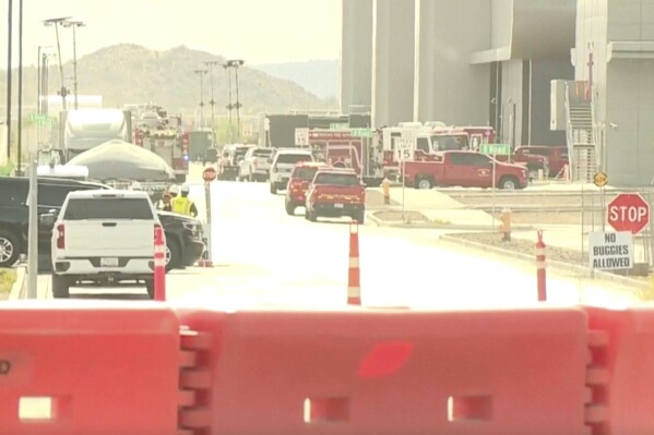 This image made from video provided by ABC15 shows emergency vehicles as they respond to the TSMC semiconductor plant under construction in Phoenix, Wednesday, May 15, 2024, after a worker was fatally injured when a tank holding waste material depressurized. He was struck and thrown over 20 feet. He died at a hospital from his injuries. (ABC15 via AP)