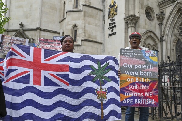 People demonstrate outside the High Court in London, Thursday, May 22, 2025, after a British court blocked the U.K. from transferring sovereignty over the Chagos Islands to Mauritius hours before the agreement was due to be signed. (AP Photo/Thomas Krych)