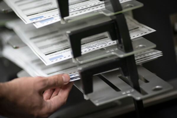 FILE - Poll workers sort out early and absentee ballots at the Kenosha Municipal Building on Election Day, Nov. 3, 2020, in Kenosha, Wis. A prosecutor urged jurors Wednesday, March 20, 2024, to find a former Milwaukee elections official who requested fake absentee ballots guilty of misconduct and fraud, rejecting her arguments that she was stressed out and only trying to expose flaws in Wisconsin's election system. (AP Photo/Wong Maye-E, File)