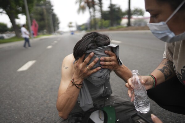 A protester is given aid during a demonstration over the dozens detained in an operation by federal immigration authorities a day earlier in Paramount section of Los Angeles Saturday, June 7, 2025. (AP Photo/Eric Thayer)