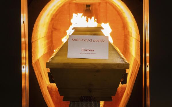 A coffin labelled with a paper 'SARS-CoV-2 positive - Corona' cremated in the crematorium in Giesen, Germany, Nov. 25, 2021. Germany’s disease control agency said it recorded 351 additional deaths in connection with the coronavirus over the past 24 hours, taking the total toll to 100,119. In Europe, Germany is the fifth country to pass that mark, after Russia, the United Kingdom, Italy and France. (Julian Stratenschulte/dpa via AP)