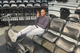 Las Vegas Aces WNBA basketball player Chelsea Gray wears a boot during a team availability at Barclays Center in New York Tuesday, Oct. 17, 2023. Gray is out at least for Game 4 of the WNBA Finals against the New York Liberty after suffering an injury to her left foot Sunday. (AP Photo/Doug Feinberg)